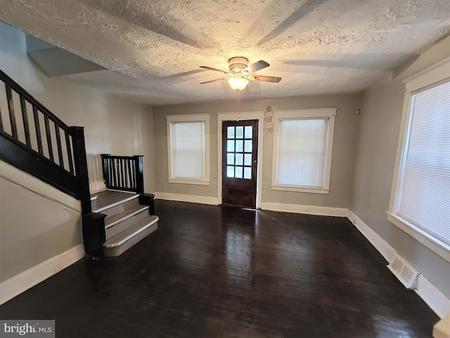 entryway with ceiling fan, a textured ceiling, and dark wood-type flooring