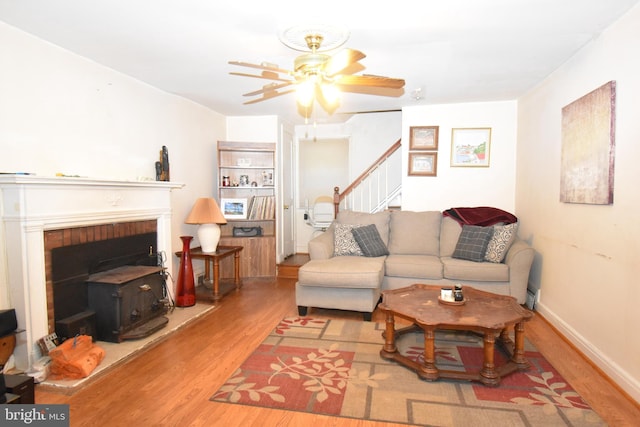 living room featuring a brick fireplace, ceiling fan, and light hardwood / wood-style flooring