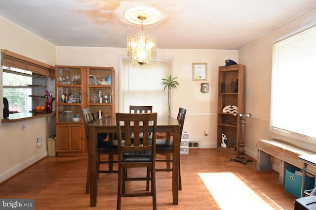 dining space with an inviting chandelier and light hardwood / wood-style flooring