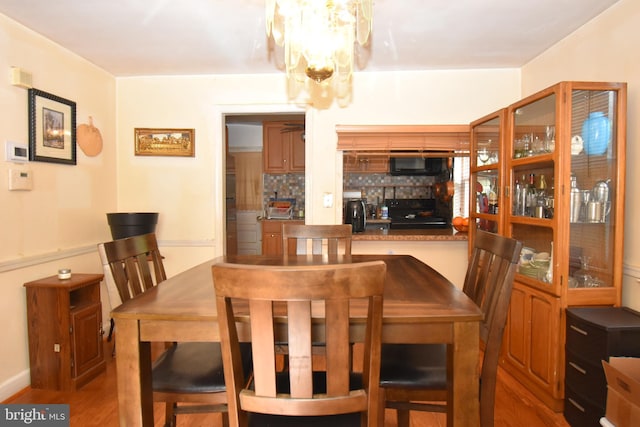 dining area featuring bar, an inviting chandelier, and dark wood-type flooring