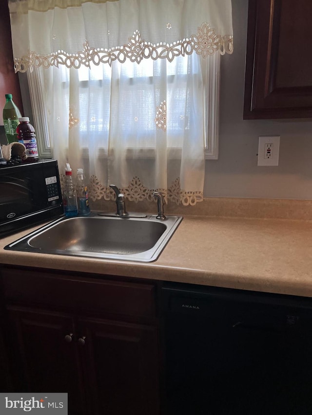 kitchen with black dishwasher, dark brown cabinets, and sink