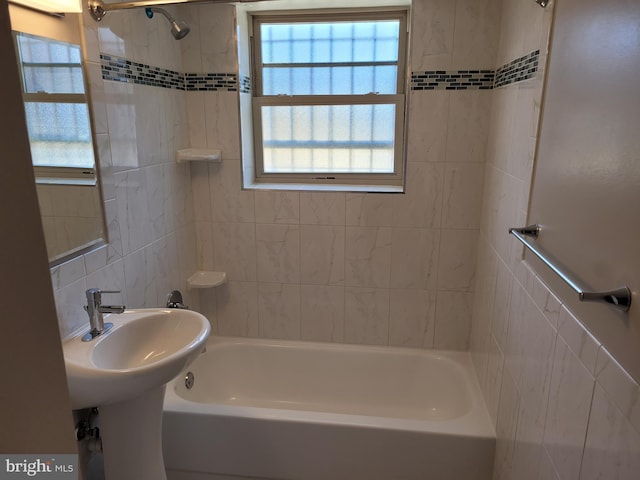 bathroom featuring tiled shower / bath, tile walls, and a wealth of natural light