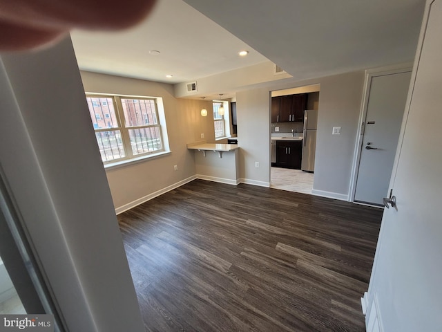 unfurnished living room with dark hardwood / wood-style flooring and sink