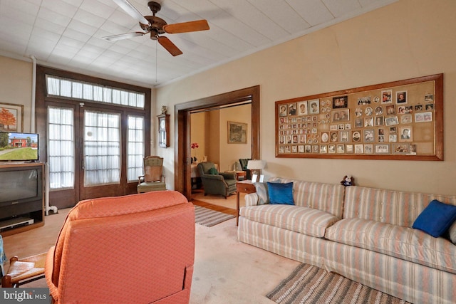 carpeted living room with ceiling fan and crown molding