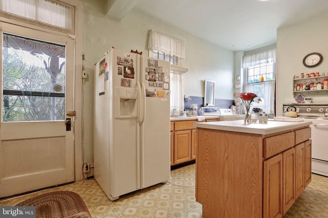 kitchen with white refrigerator with ice dispenser and a kitchen island