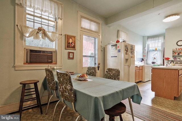 dining space with cooling unit, beam ceiling, and washer / clothes dryer