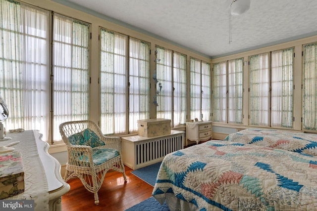 bedroom featuring a textured ceiling and hardwood / wood-style flooring