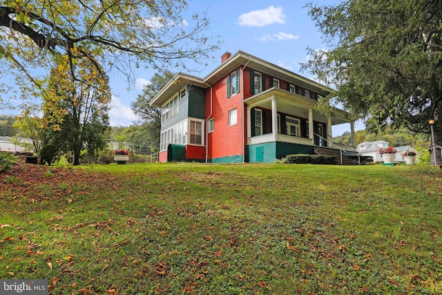 view of side of home featuring a lawn and a balcony