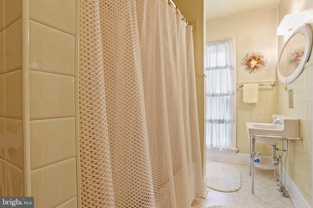 bathroom featuring tile walls and a shower with shower curtain