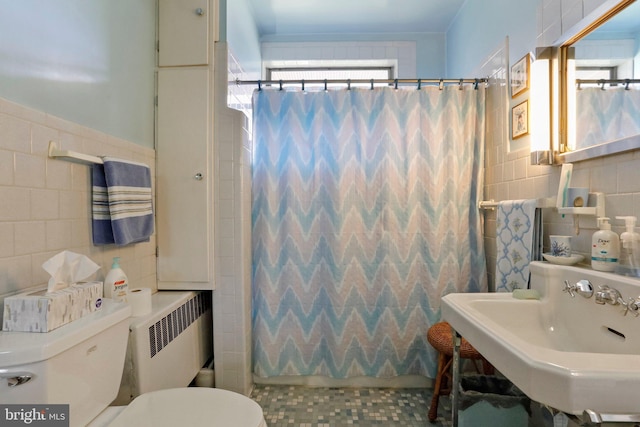 full bathroom with radiator heating unit, sink, tile walls, toilet, and shower / tub combo with curtain