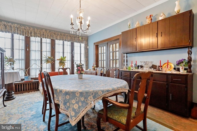 dining area featuring ornamental molding, light hardwood / wood-style floors, and a notable chandelier