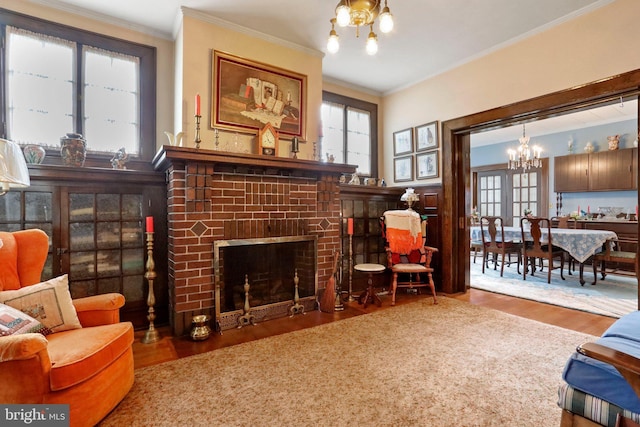 living area with a brick fireplace, dark hardwood / wood-style flooring, ornamental molding, and a chandelier