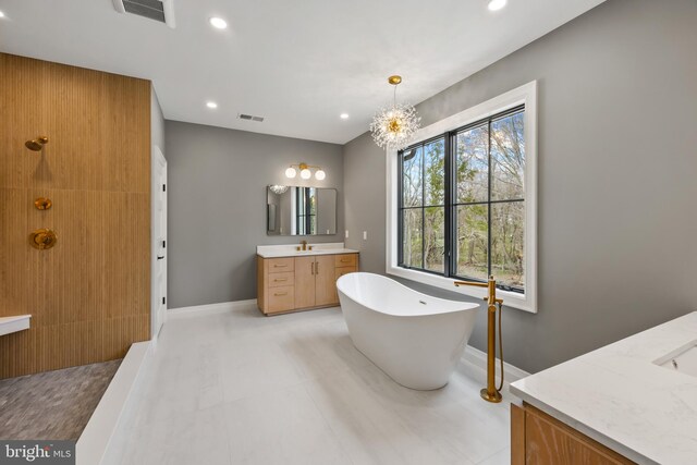 bathroom with recessed lighting, visible vents, a soaking tub, and vanity