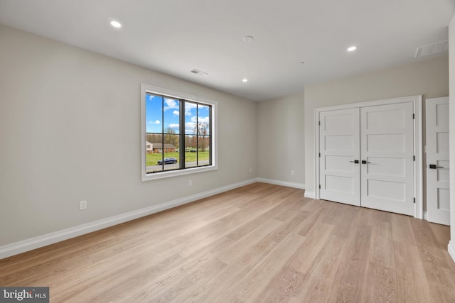 unfurnished bedroom with a closet, visible vents, light wood finished floors, baseboards, and recessed lighting