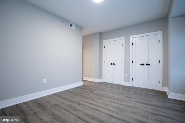 unfurnished room with dark wood-type flooring