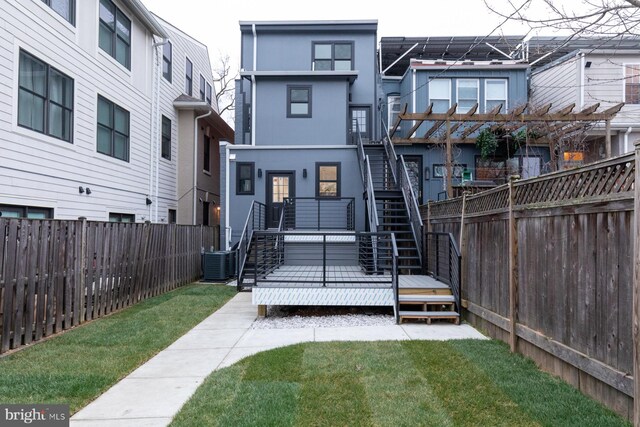 back of house featuring a yard and central AC