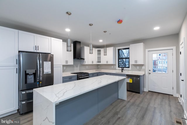 kitchen with stainless steel fridge with ice dispenser, dishwashing machine, wall chimney exhaust hood, white cabinetry, and light wood-type flooring