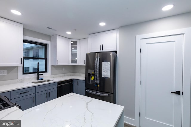 kitchen featuring dishwasher, sink, stainless steel fridge with ice dispenser, light stone countertops, and white cabinets