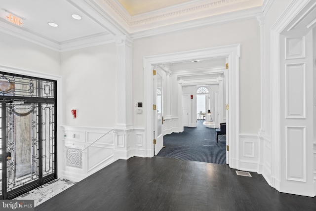 foyer featuring crown molding and dark wood-type flooring