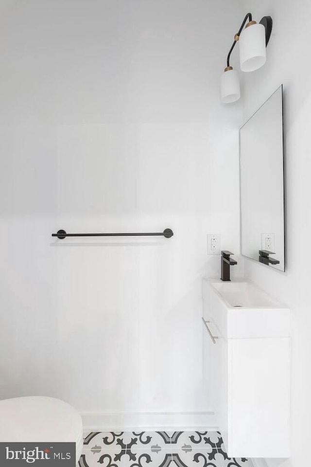 bathroom with toilet, tile flooring, and vanity