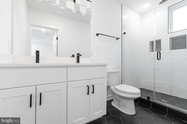 bathroom featuring toilet, a shower with door, tile floors, and large vanity