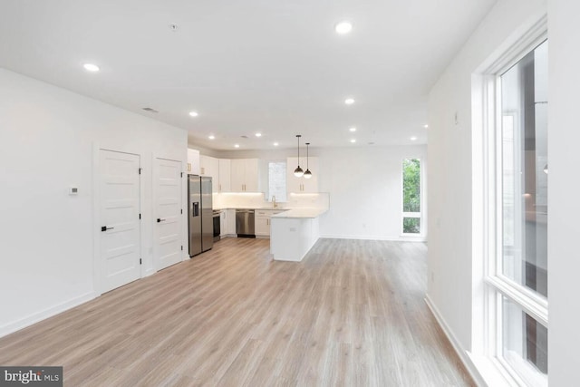 unfurnished living room with light wood-type flooring and sink