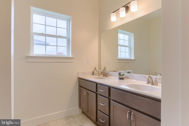 bathroom with tile flooring, dual vanity, and plenty of natural light