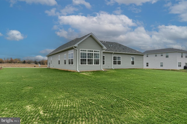 rear view of house featuring a yard