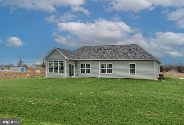 rear view of property featuring central AC unit and a yard