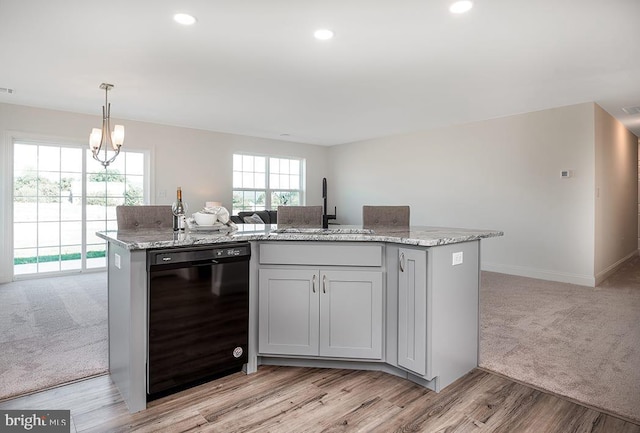 kitchen with light stone counters, light carpet, a notable chandelier, dishwasher, and sink