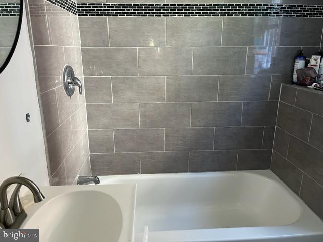 bathroom with sink and tiled shower / bath