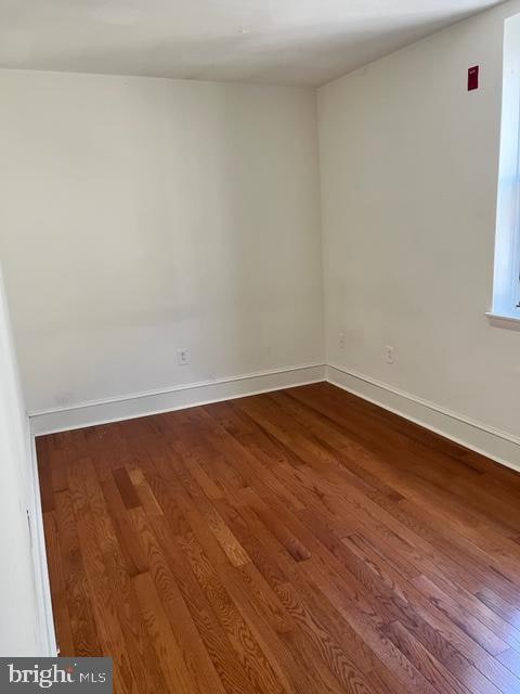 unfurnished room featuring dark hardwood / wood-style floors