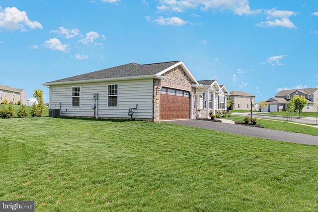 view of front facade with central air condition unit, a front lawn, and a garage