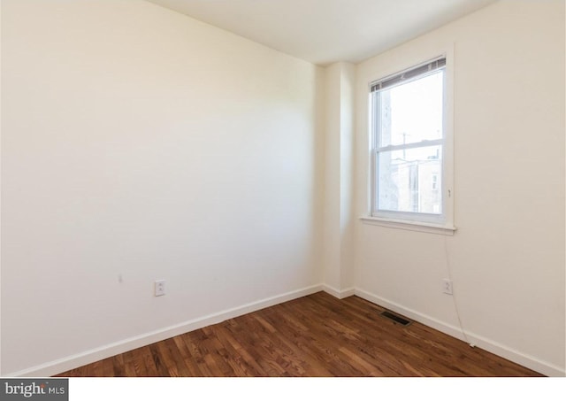 unfurnished room with dark hardwood / wood-style flooring