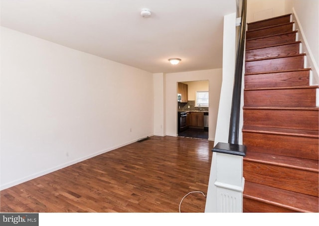 stairway with dark hardwood / wood-style flooring