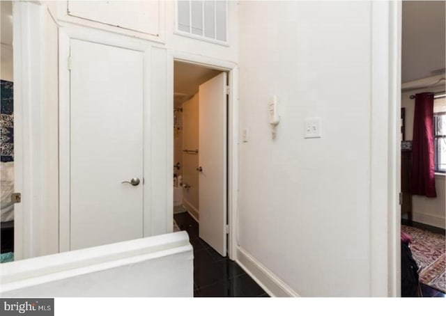 hallway with dark tile floors