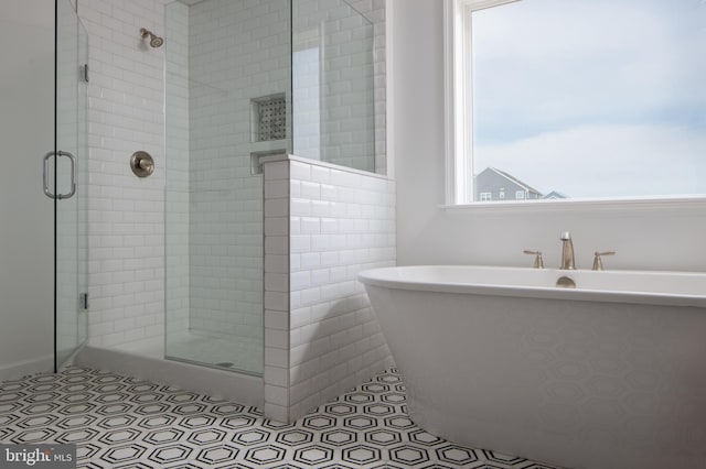 bathroom featuring separate shower and tub, tile patterned floors, and tile walls