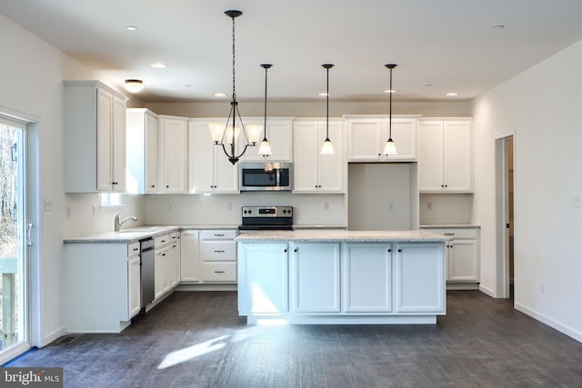 kitchen featuring white cabinetry, appliances with stainless steel finishes, hanging light fixtures, and dark hardwood / wood-style floors