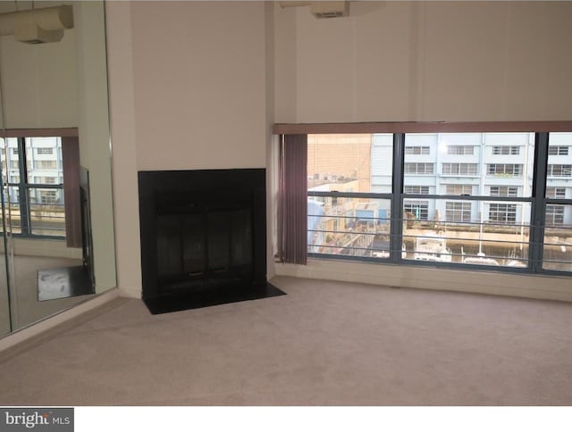 unfurnished living room with light carpet and plenty of natural light