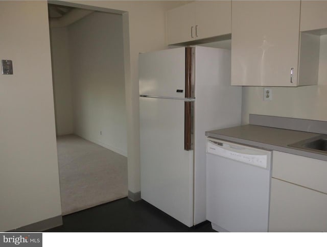 kitchen featuring white cabinets, dishwasher, and dark carpet