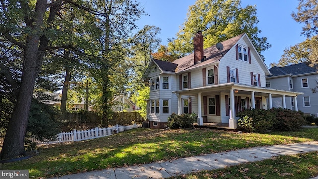 view of front facade featuring covered porch, a front lawn, and central air condition unit