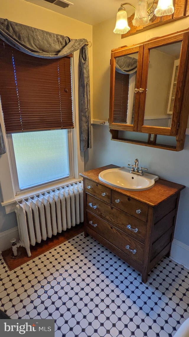 bathroom with radiator heating unit, tile flooring, and vanity