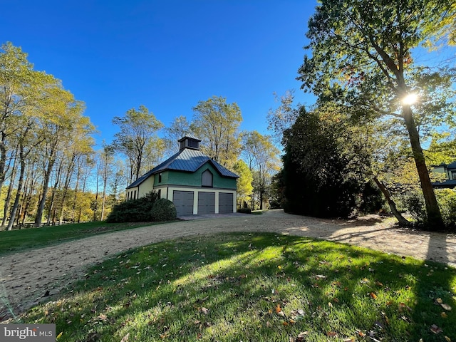 exterior space featuring a garage and a lawn