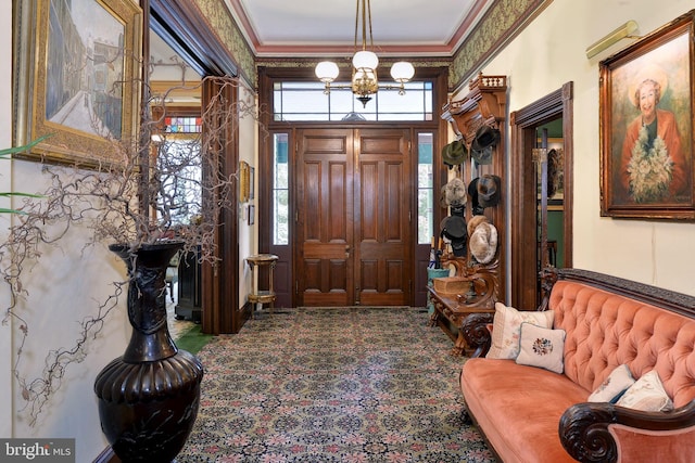 entrance foyer featuring ornamental molding and a notable chandelier