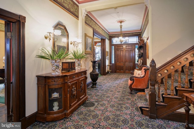 foyer entrance featuring ornamental molding and a notable chandelier