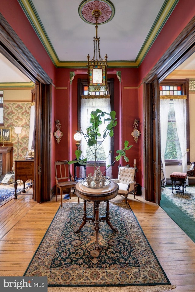 sitting room featuring hardwood / wood-style flooring, a wealth of natural light, and crown molding