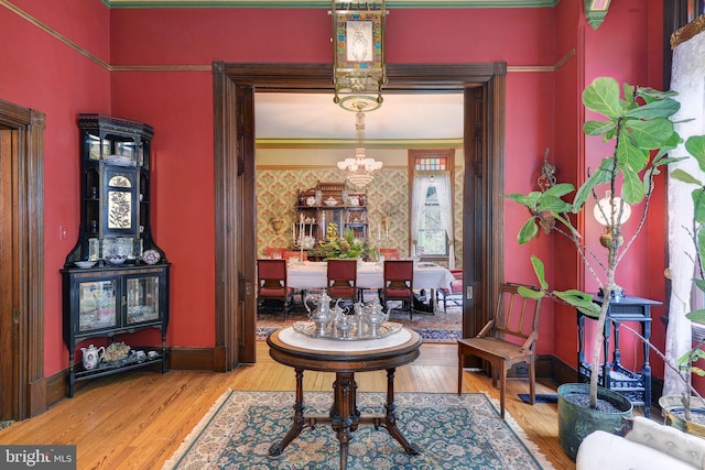 interior space with ornamental molding, wood-type flooring, and an inviting chandelier