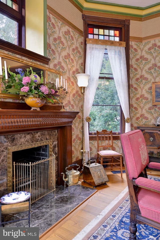 sitting room with a wealth of natural light, a towering ceiling, and wood-type flooring