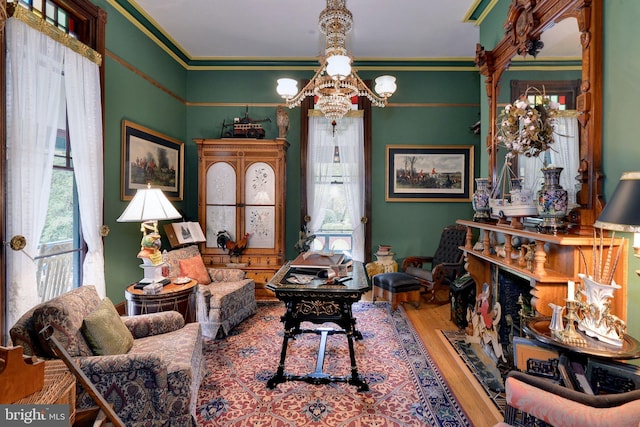 interior space featuring a healthy amount of sunlight, wood-type flooring, ornamental molding, and an inviting chandelier