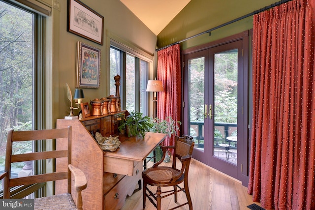 dining area with french doors, lofted ceiling, and light hardwood / wood-style flooring